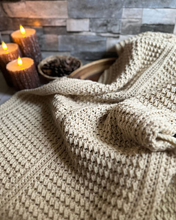 Finished Vanilla Vista crochet blanket folded on a wooden surface, showing the neat texture created by a single easy stitch