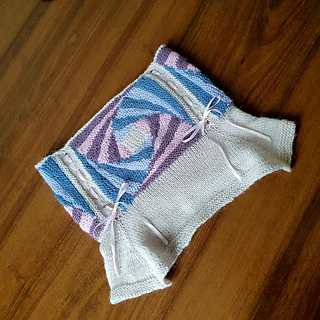 a knitted spiral striped cowl with flared yoke and ribbon lacing.