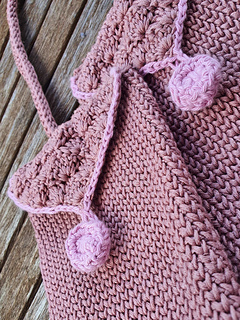 close-up of brown and pink crocheted bag with shell stitch flap and crocheted buttons