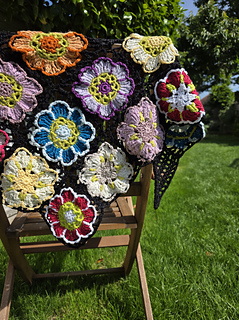 Black lace triangular shawl with bright floral granny squares draped over chair