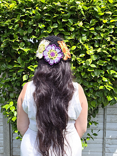 Black lace headscarf with bright floral granny squares worn, seen from back