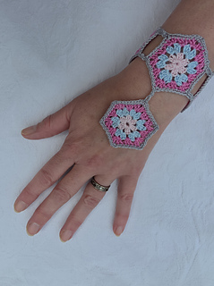 hand on table wearing crochet hexagon cuff.