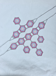 crocheted hexagon jewellery laid out on a tablecloth