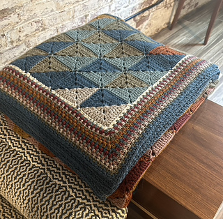 Folded blanket, showing the day-square triangles and moss stitch border detail