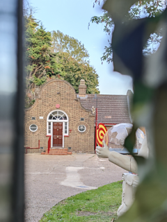 A view of Taskmaster House through the gate, photographed in September 2025