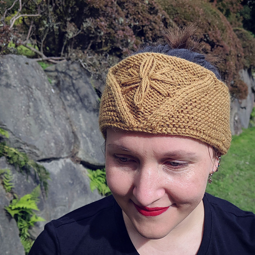 A garter stitch headband worked in the round with a V detail in the front and a star that is added later with an embroidery needle.