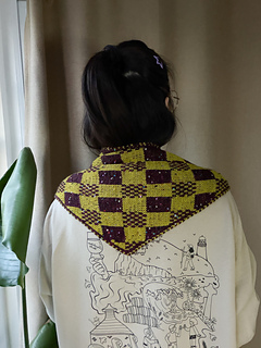 Checkmate face worn across the shoulders, seen from the back.