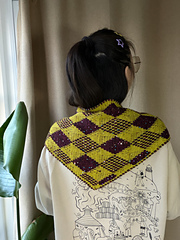 Harlequin diamond face worn across the shoulders, seen from the back.