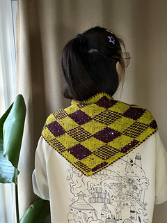 Harlequin diamond face worn across the shoulders, seen from the back.