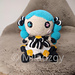 Gwen from League of Legends, crochet toy made by amigurumi technique. Used turqoise blue, dark gray, white, yellow, beige, pink and light pink yarn. Front view. Smiley face, white dress with dark gray outbound, blue and pink pupil in button eyes, blue hair in two blue curled up braids.