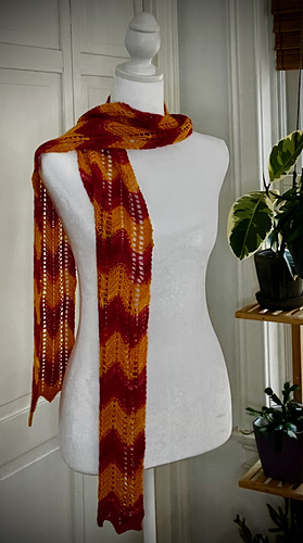 scarf draped over dress form with plant on right side