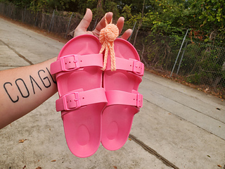 Hot pink slides hanging off my pastel orange Shower Sandal Holder.