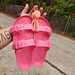 Hot pink slides hanging off my pastel orange Shower Sandal Holder.