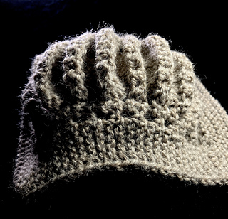 Swatch placed on a ball of yarn to show scarf texture 