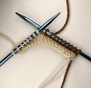 3 tan rows followed by 1 brown row. The tan yarn is left at the left edge and the brown yarn is started at the right edge.